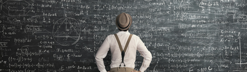 man looking at complex math on the board